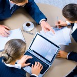 Image of three business people working at meeting