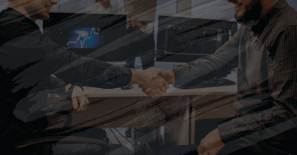 Aperto de mão entre profissionais para ilustrar texto sobre Implantação de sistema